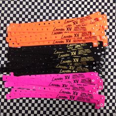 five pairs of black, pink, and orange hair clips on a checkered tablecloth