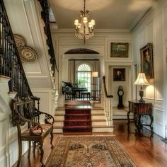 an ornate entry way with stairs and chandelier