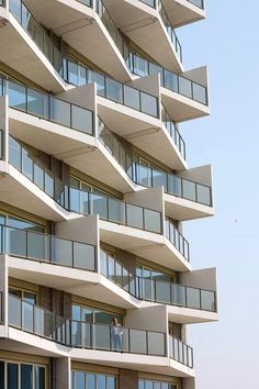 a man on a skateboard in front of an apartment building with balconies