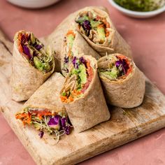 there are several burritos that have been cut in half and stacked on a cutting board