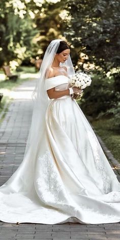 a woman in a wedding dress is walking down the street