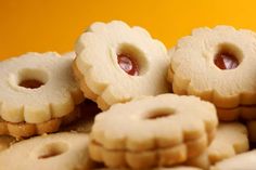 some cookies with jelly on them are arranged in a pile and one has been cut into smaller pieces