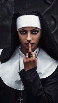 a woman dressed in nun costume holding her finger up