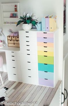 a white dresser with drawers and colorful drawers