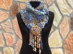 a mannequin wearing a blue and gold crocheted scarf