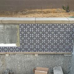 a cement bench sitting next to a concrete wall