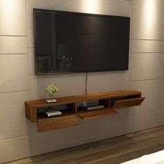 there is a tv on the wall in this room with wood flooring and white walls