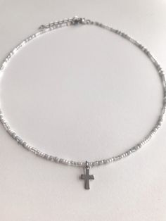 This dainty Seed Bead Choker Necklace with a delicate stainless steel cross charm(the jump-rings that attached to the charm to the necklaces are also stainless steel) is made with pretty multi-colored grey, white, and silver glass seed beads. The tiny seed beads are strung on beading wire & finished with a stainless steel lobster style clasp with a 2 inch stainless steel extension chain, to allow for personal size adjustments. These necklaces are perfect for everyday wear. Enjoy a cute simpl Silver Cross Beaded Necklace For Spiritual Style, Silver Spiritual Cross Beaded Necklace, Spiritual Silver Cross Beaded Necklace, Cross Necklace With Silver Beads For Gift, Dainty Silver Beaded Charm Necklaces, Dainty Silver Beaded Charm Necklace, Beaded Cross Pendant Necklace As A Gift, Silver Charm Necklace With Tiny Beads For Gift, Silver Beaded Cross Necklace For Gift