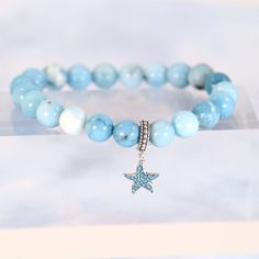 Experience the calming energy of the ocean with our Ocean Starfish Larimar Beaded Bracelet. This beautiful bracelet features a Larimar beaded strand, known for its soothing and healing properties, and is adorned with a charming starfish pendant charm made of solid 925 sterling silver. Add a touch of elegance and serenity to your wardrobe. Materials: Larimar, 925 sterling silver You can choose the option with the starfish charm or without the starfish charm. Jewelry Care: See more information about how to care for your jewelry here. Shipping Policy: Orders will be shipped within 1-3 business days. Economy shipping will take 7-14 days to arrive and standard shipping is 1- 4 days for U.S. orders. International shipping time is depended on the country and per shipping method. Shipping cost wil Turquoise Starfish Beaded Bracelets, Ocean-inspired, Turquoise Beaded Bracelets With Starfish Charm, Ocean-inspired Turquoise Starfish Beaded Bracelets, Ocean Starfish, Starfish Pendant, Silver Jewelry Earrings, Handmade Fashion Jewelry, Screw Back Earrings, Bead Strand