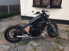 a black motorcycle parked in front of a house