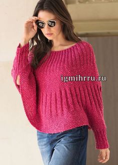 a woman is wearing a pink sweater and jeans while holding her hand on her head