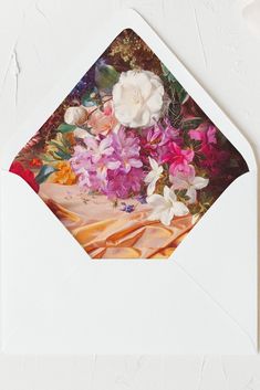 an open envelope with flowers in it