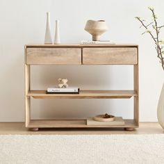 a wooden shelf with two drawers next to a vase and other items on the table