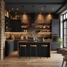 an open kitchen with brick walls and wooden floors, along with bar stools that match the hardwood flooring