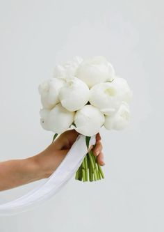 a person holding a bouquet of white flowers