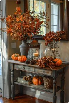 a console table with pumpkins and gourds on it