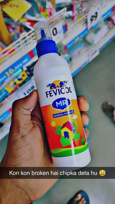 a person holding a bottle of fevicol mr in front of a store shelf