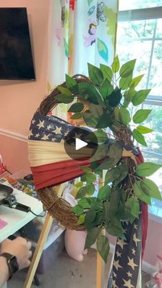 an american flag wreath is on display in the corner of a room with pink walls