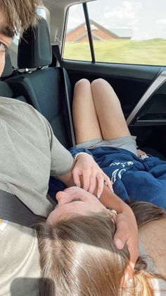 two people sitting in the back seat of a car