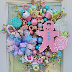 a wreath made out of candy, candies and other items is hanging on the front door