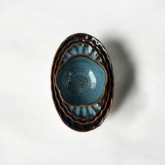 a blue and brown bowl sitting on top of a white table