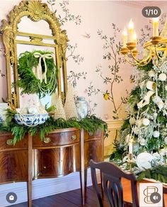 a decorated christmas tree sitting next to a table with a mirror on top of it