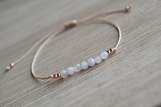 Natural moonstone string bracelet; simple string wish bracelet - Minimalist string bracelet with adjustable sliding closure. - Dainty rose gold plated stainless steel beads. - 4 mm round faceted tiny white moonstone beads. - Beige strong string. - A string bracelet is a symbolic gift to be offered to anyone, as a lucky charm bracelet - Ready to give it as a gift this bracelet comes wrapped in one nice jewelry bag. If you have any questions about this item please feel free to leave a message. If Dainty White Jewelry With Sliding Knot, Adjustable Rose Gold Moonstone Jewelry, Handmade Rose Gold Minimalist Beaded Bracelets, Handmade Minimalist Rose Gold Beaded Bracelets, Minimalist Handmade Moonstone Bracelets, Dainty Moonstone Beaded Bracelet With Adjustable Fit, Dainty Moonstone Beaded Bracelets Adjustable, Adjustable Moonstone Beaded Bracelet, Dainty Adjustable Moonstone Beaded Bracelet