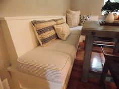 a living room with a white couch and wooden table in it's center area