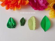 four different types of paper flowers on a white surface