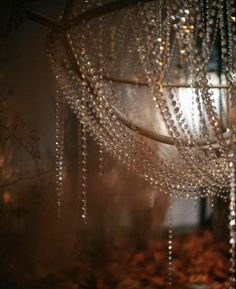 a chandelier hanging from the ceiling in front of a window filled with raindrops