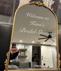 a woman taking a selfie in front of a mirror with the words, welcome to kana's bridal shower written on it