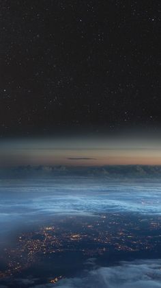 the night sky is filled with stars and clouds as seen from an airplane in the air