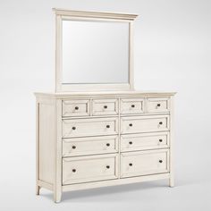 a white dresser with a mirror on top of it and drawers in front of it