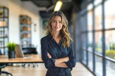 a woman standing in an office with her arms crossed