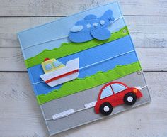 a book with an airplane, car and boat on the cover sitting on a white wooden surface