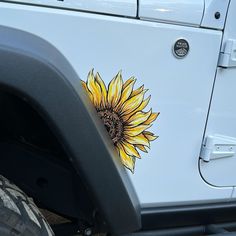 a sunflower sticker on the side of a white jeep with it's door open