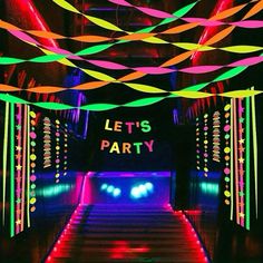 an indoor party with neon lights and streamers