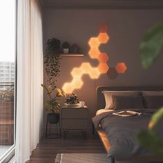 a bedroom with hexagonal lights on the wall, and a bed in front of a window