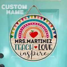 a wooden sign that says, teacher love inspires you in front of a blue door