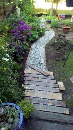 a wooden walkway in the middle of a garden