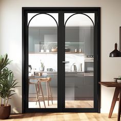 an open kitchen and dining room area with black glass doors that lead to the outside