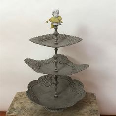 three tiered metal tray with an animal figurine on top