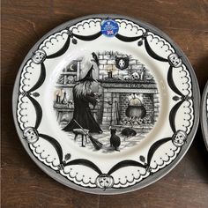 two plates with black and white designs on them, one has a witch in the kitchen