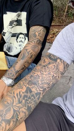 two men with tattoos sitting next to each other