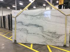 a large marble slab in a warehouse with yellow tape around the edges and an open door