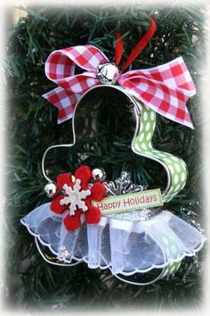 a christmas ornament hanging from a tree with red and white bows on it