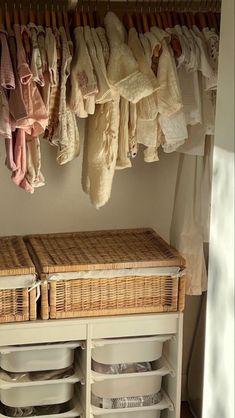 an organized closet with baskets and clothes hanging on the rack, next to a white dresser