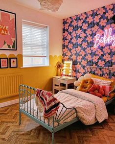 a bed room with a neatly made bed and a neon sign above the headboard