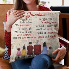 a woman sitting on a chair holding up a pillow with the words grandma printed on it