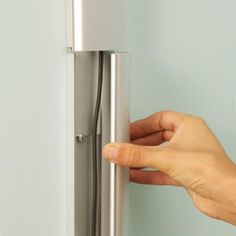 a hand is holding the door handle on a refrigerator